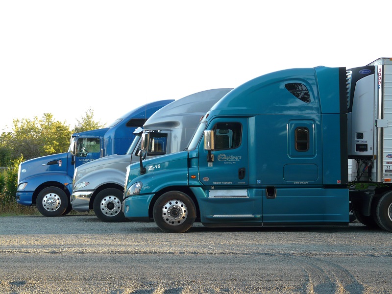 A picture of 3 blue trucks lined up